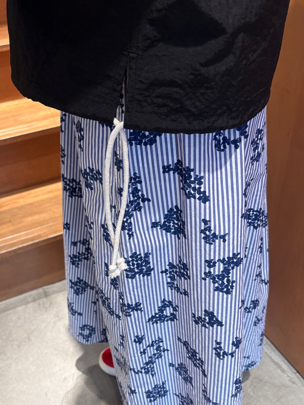 ホワイト系のTシャツ/カットソー、ブラック系のその他アウター、ブルー系のスカートを着用したレディースの春コーディネートの9枚目の写真