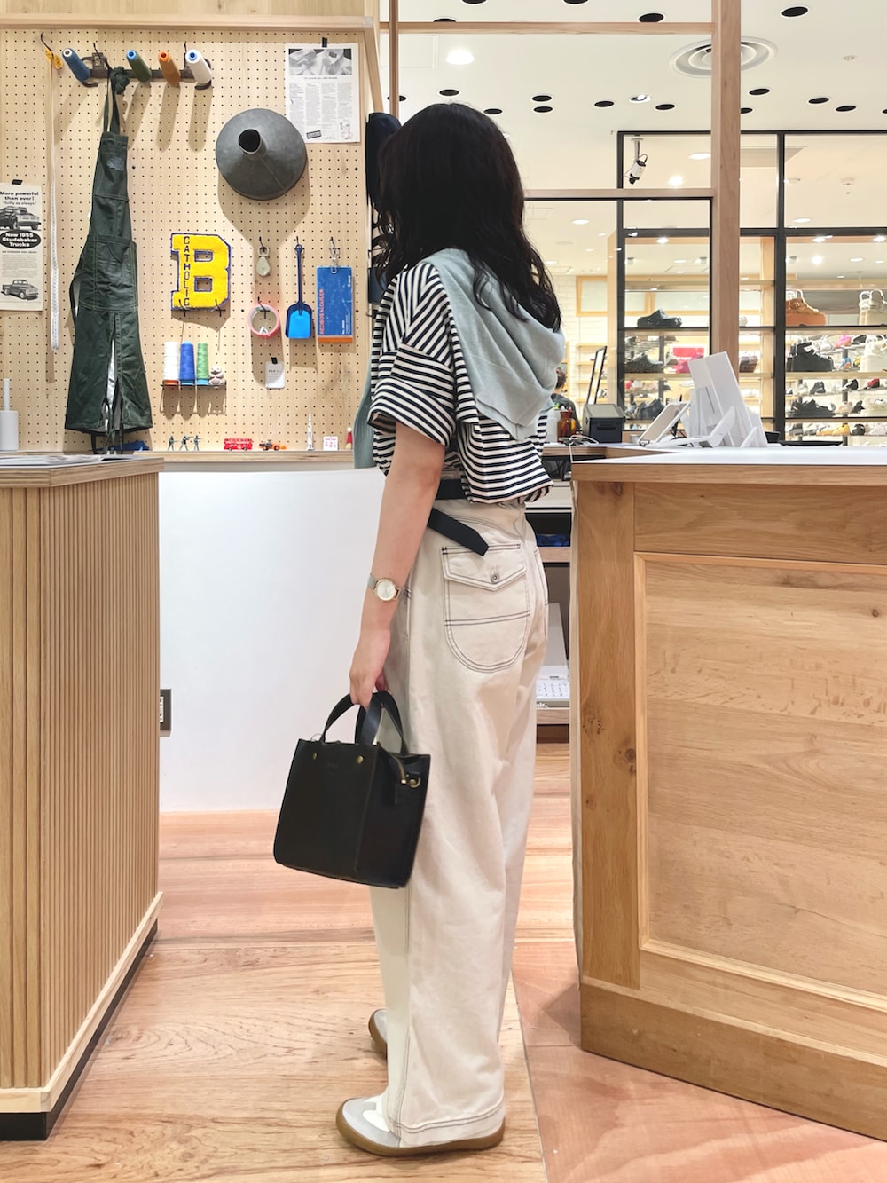 グリーン系のTシャツ/カットソー、ブルー系のカーディガン/ボレロ、ホワイト系のデニムパンツを着用したレディースの夏コーディネートの2枚目の写真