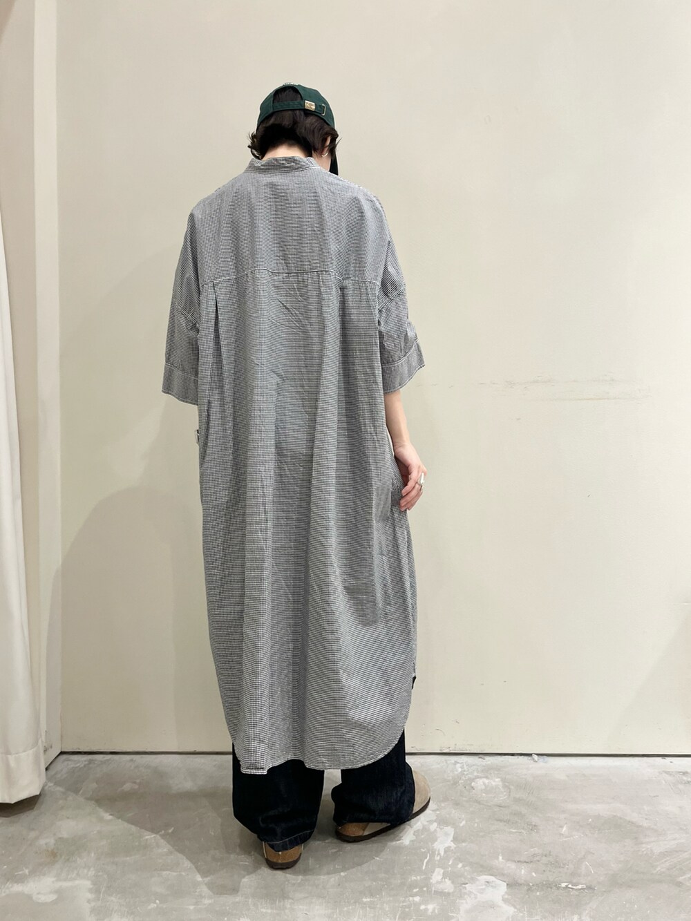 ブラック系のシャツワンピース、ブルー系のデニムパンツを着用したレディースの夏コーディネートの3枚目の写真