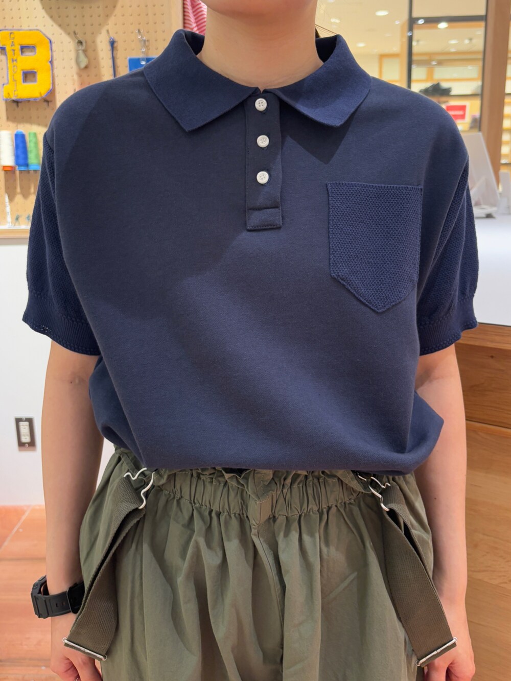 ブルー系のポロシャツ、グリーン系のその他パンツを着用したレディースの春コーディネートの4枚目の写真