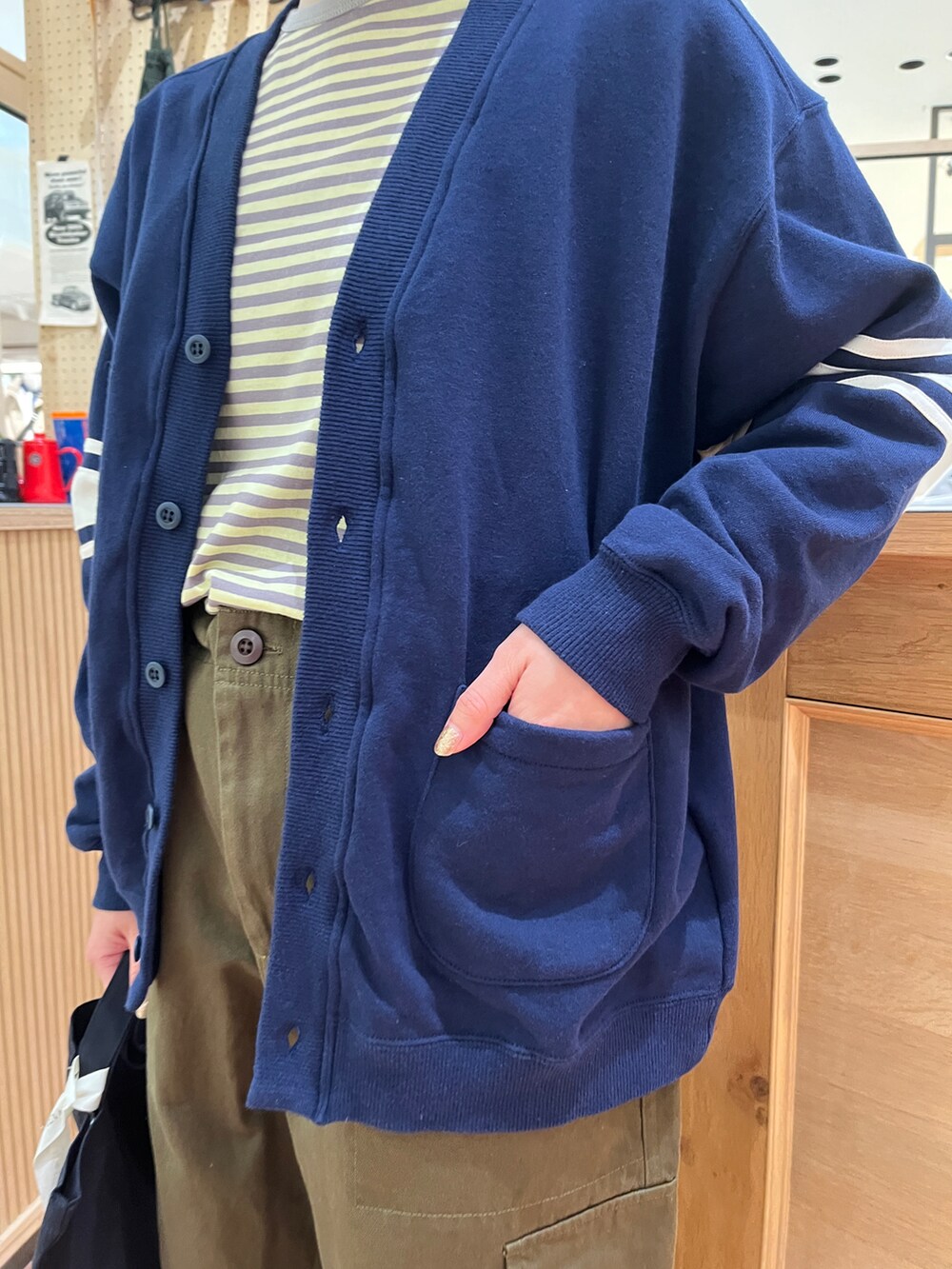 イエロー系のTシャツ/カットソー、ブルー系のカーディガン/ボレロ、グリーン系のカーゴパンツを着用したレディースの冬コーディネートの4枚目の写真