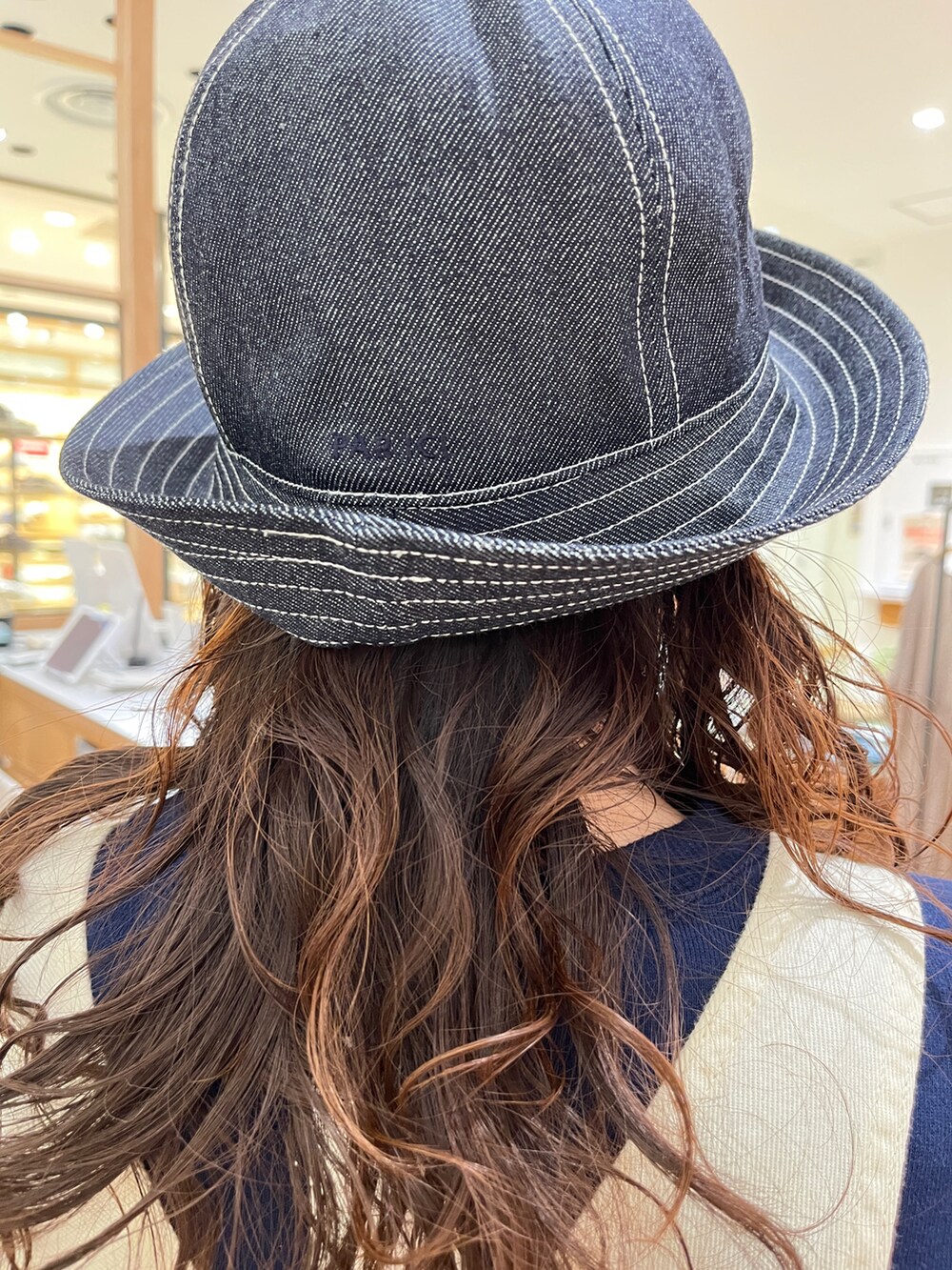 ブルー系のスウェット、ホワイト系のサロペット/オーバーオール、ブルー系のハットを着用したレディースの冬コーディネートの5枚目の写真