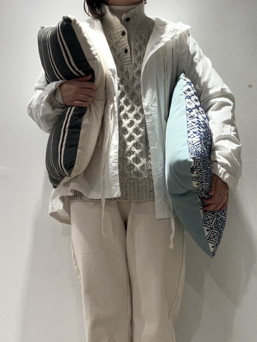 ホワイト系のニット/セーター、ホワイト系のデニムパンツ、ホワイト系のTシャツ/カットソーを着用したレディースの冬コーディネートの4枚目の写真