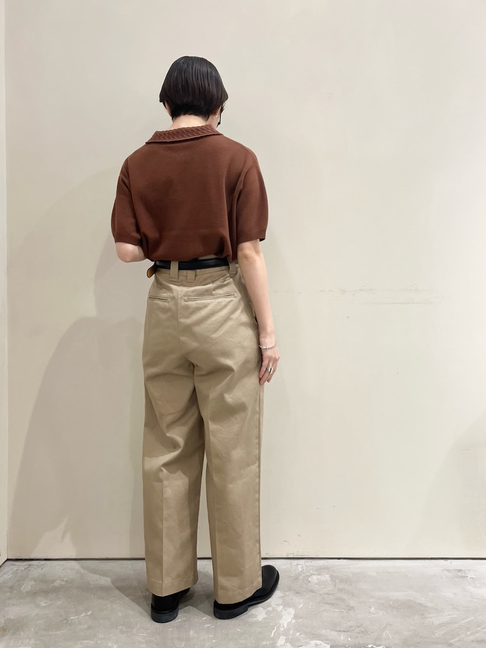 ブラウン系のポロシャツを着用したレディースの春コーディネートの3枚目の写真