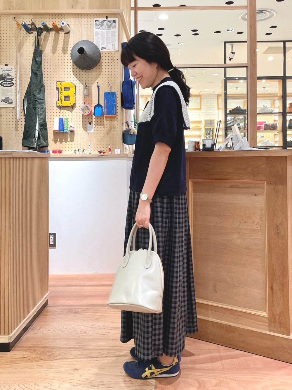 グレー系のスカート、ブルー系のTシャツ/カットソー、ホワイト系の付け襟を着用したレディースの夏コーディネートの2枚目の写真