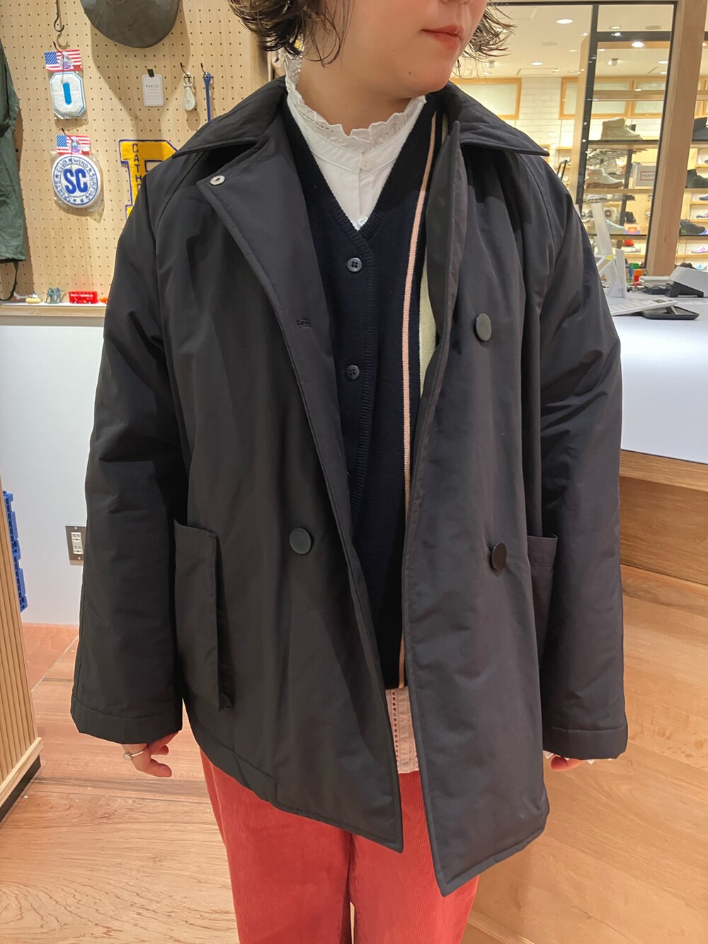 ブラック系のブルゾン、ホワイト系のシャツ/ブラウス、ブルー系のベストを着用したレディースの秋コーディネートの4枚目の写真