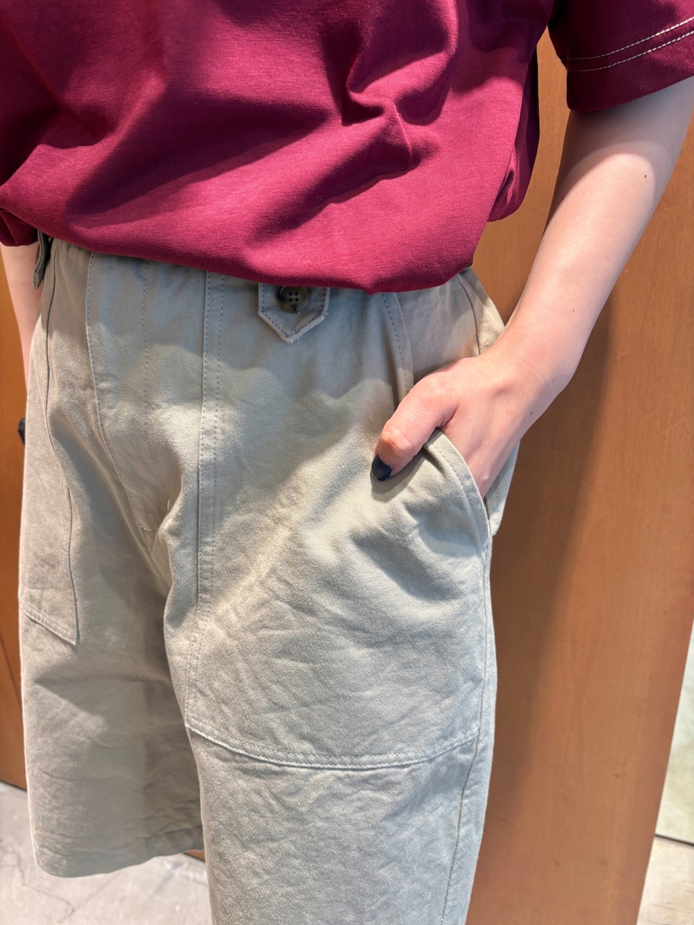 レッド系のTシャツ/カットソー、ベージュ系のチノパンツ、ブラック系のベルトを着用したレディースの夏コーディネートの6枚目の写真