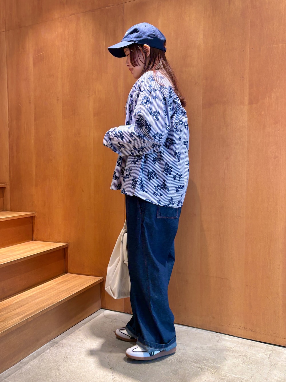 ホワイト系のTシャツ/カットソー、ブルー系のシャツ/ブラウス、ホワイト系のトートバッグを着用したレディースの春コーディネートの3枚目の写真