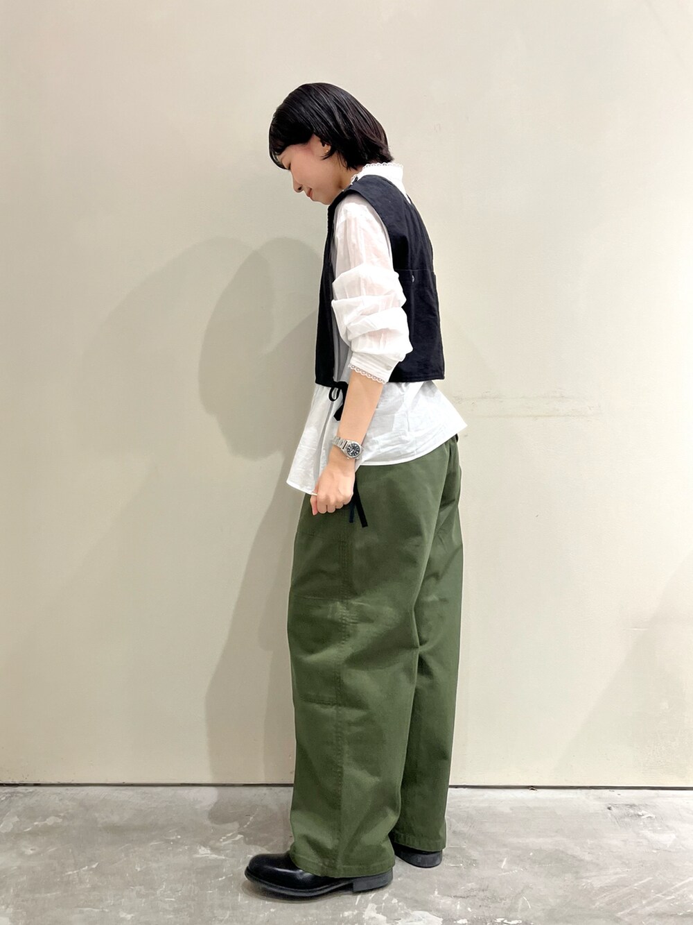 ブラック系のベスト、ホワイト系のシャツ/ブラウス、グリーン系のその他パンツを着用したレディースの夏コーディネートの2枚目の写真
