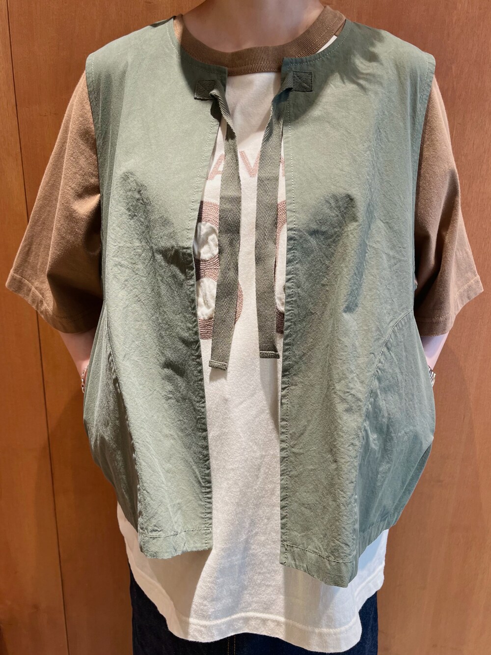 ブラウン系のTシャツ/カットソー、グリーン系のベスト、ブルー系のデニムスカートを着用したレディースの夏コーディネートの3枚目の写真