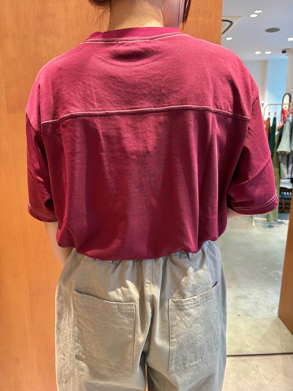 レッド系のTシャツ/カットソー、ベージュ系のチノパンツ、ブラック系のベルトを着用したレディースの夏コーディネートの5枚目の写真