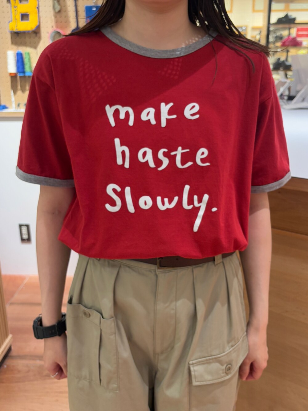 レッド系のTシャツ/カットソー、ベージュ系のその他パンツ、ブラウン系のベルトを着用したレディースの春コーディネートの5枚目の写真