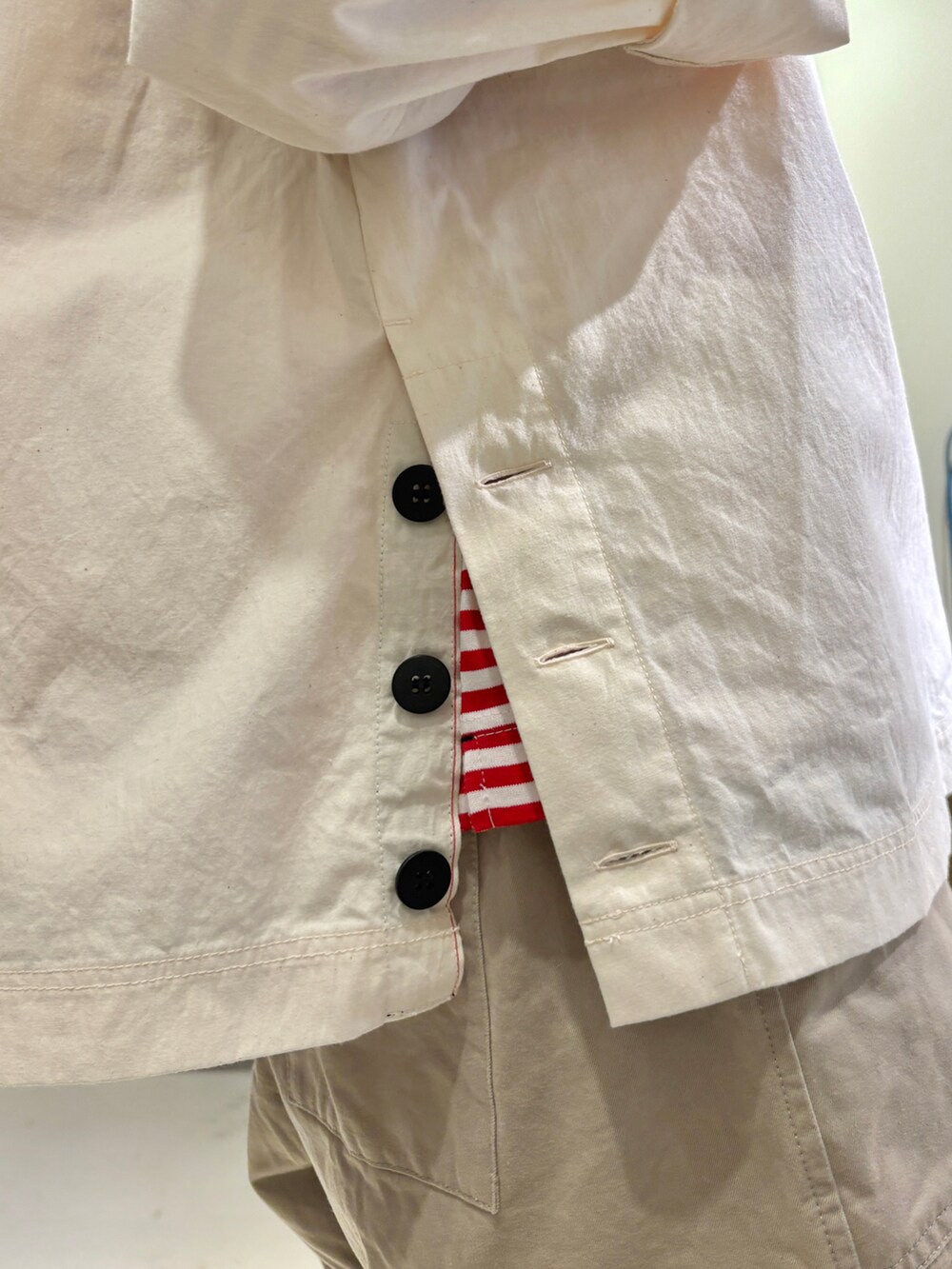 ホワイト系のシャツ/ブラウス、レッド系のTシャツ/カットソー、ベージュ系のチノパンツを着用したレディースの夏コーディネートの5枚目の写真