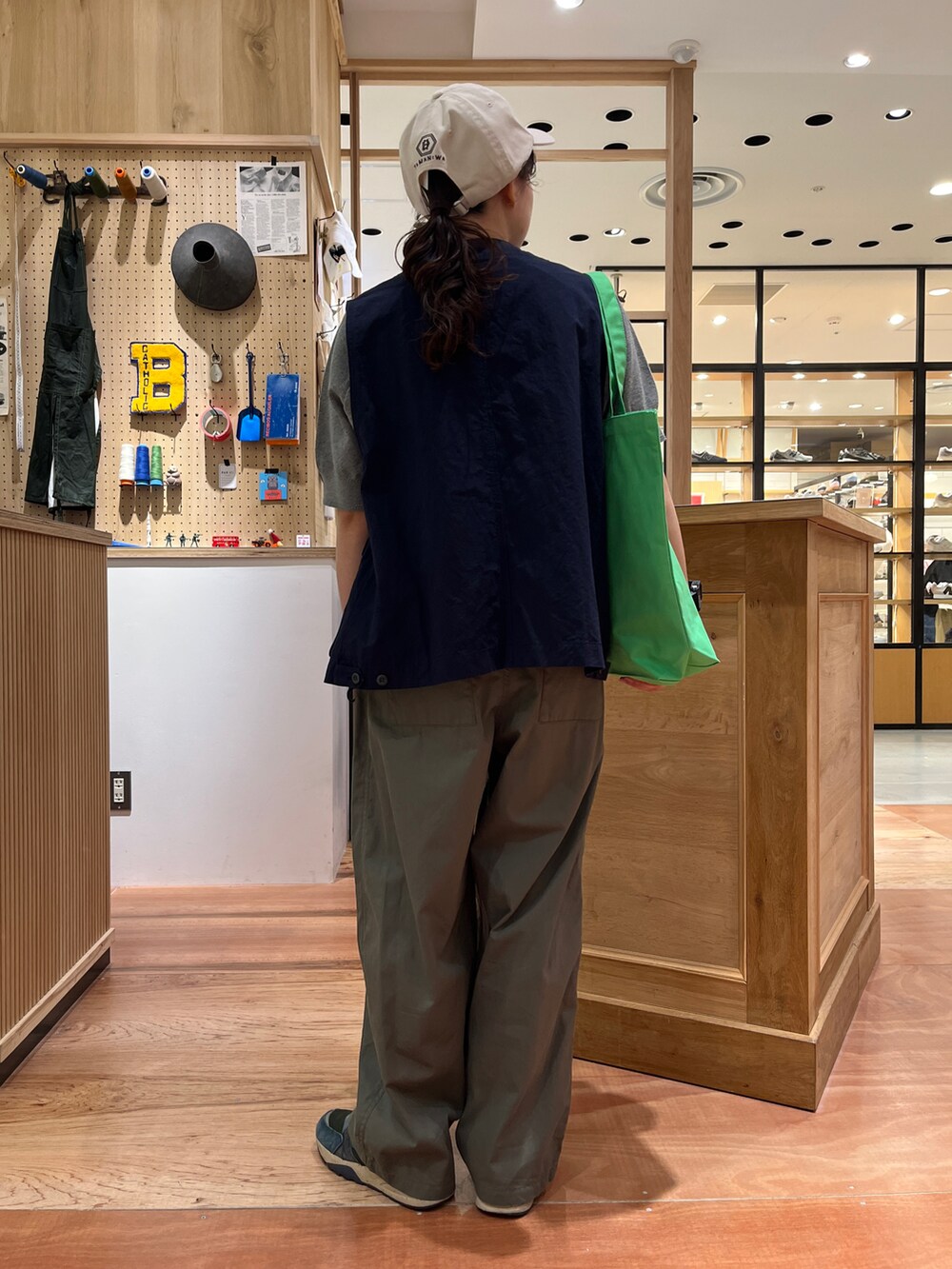 イエロー系のTシャツ/カットソー、ブルー系のベスト、グリーン系のその他パンツを着用したレディースの春コーディネートの3枚目の写真