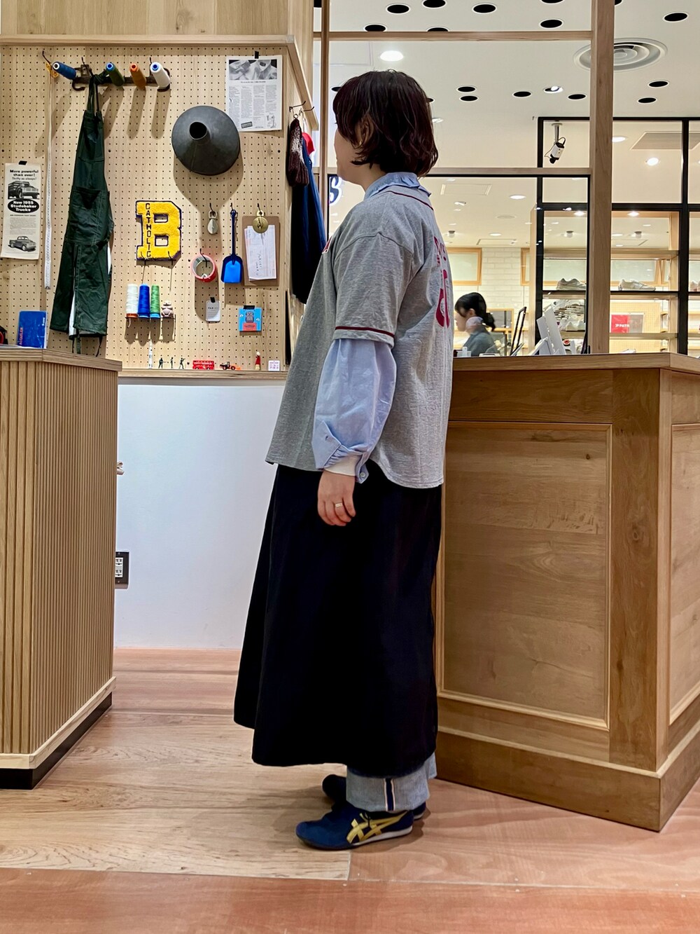 ブルー系のシャツ/ブラウス、グレー系のTシャツ/カットソー、ブラック系のワンピースを着用したレディースの春コーディネートの2枚目の写真