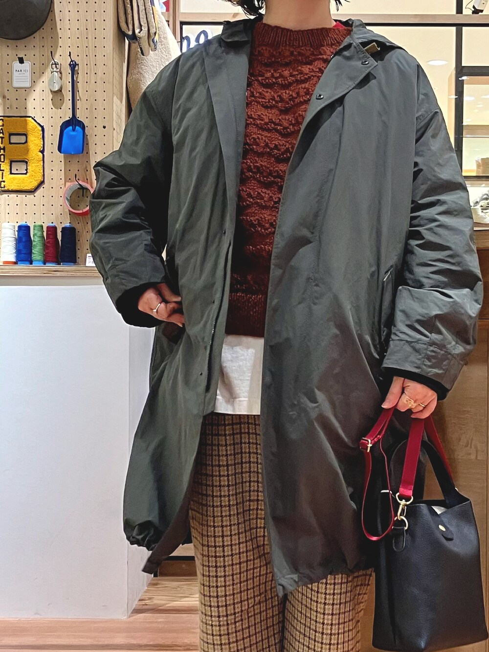 グリーン系のモッズコート、ブラウン系のベストを着用したレディースの秋コーディネートの2枚目の写真