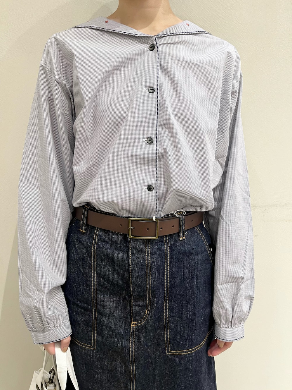 ブルー系のシャツ/ブラウス、ブルー系のデニムスカート、ホワイト系のトートバッグを着用したレディースの冬コーディネートの3枚目の写真