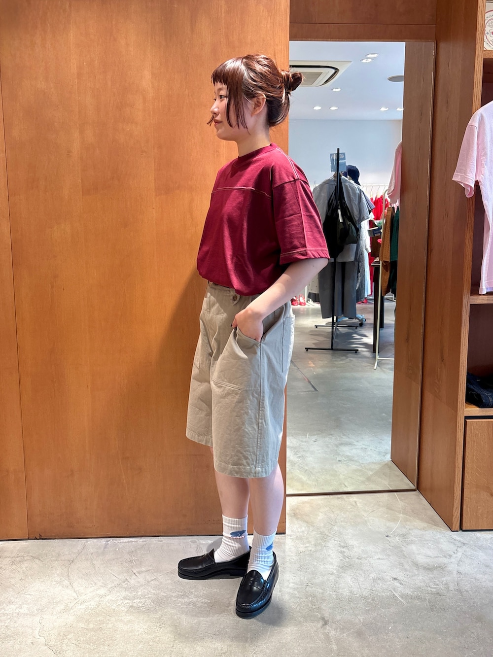 レッド系のTシャツ/カットソー、ベージュ系のチノパンツ、ブラック系のベルトを着用したレディースの夏コーディネートの2枚目の写真