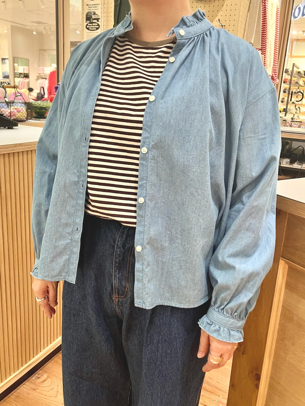ブラウン系のTシャツ/カットソー、ブルー系のシャツ/ブラウス、ブルー系のデニムパンツを着用したレディースの秋コーディネートの3枚目の写真