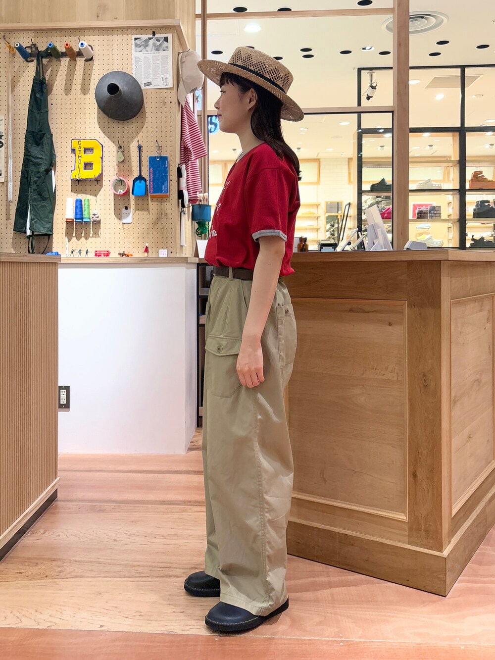 レッド系のTシャツ/カットソー、ベージュ系のその他パンツ、ブラウン系のベルトを着用したレディースの春コーディネートの2枚目の写真