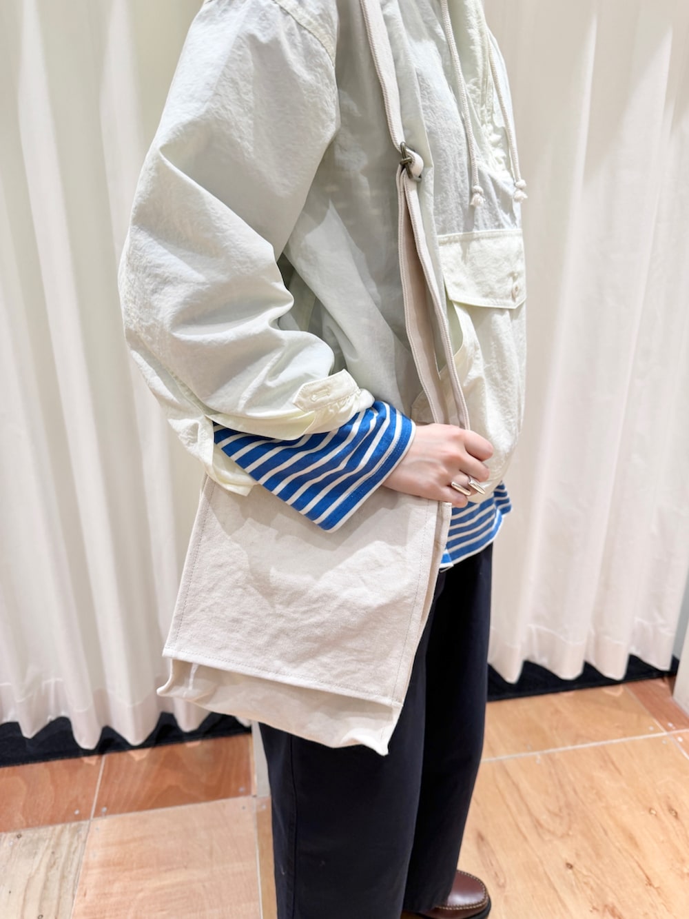 ホワイト系のその他アウター、ブルー系のチノパンツ、ホワイト系のショルダーバッグを着用したレディースの春コーディネートの3枚目の写真