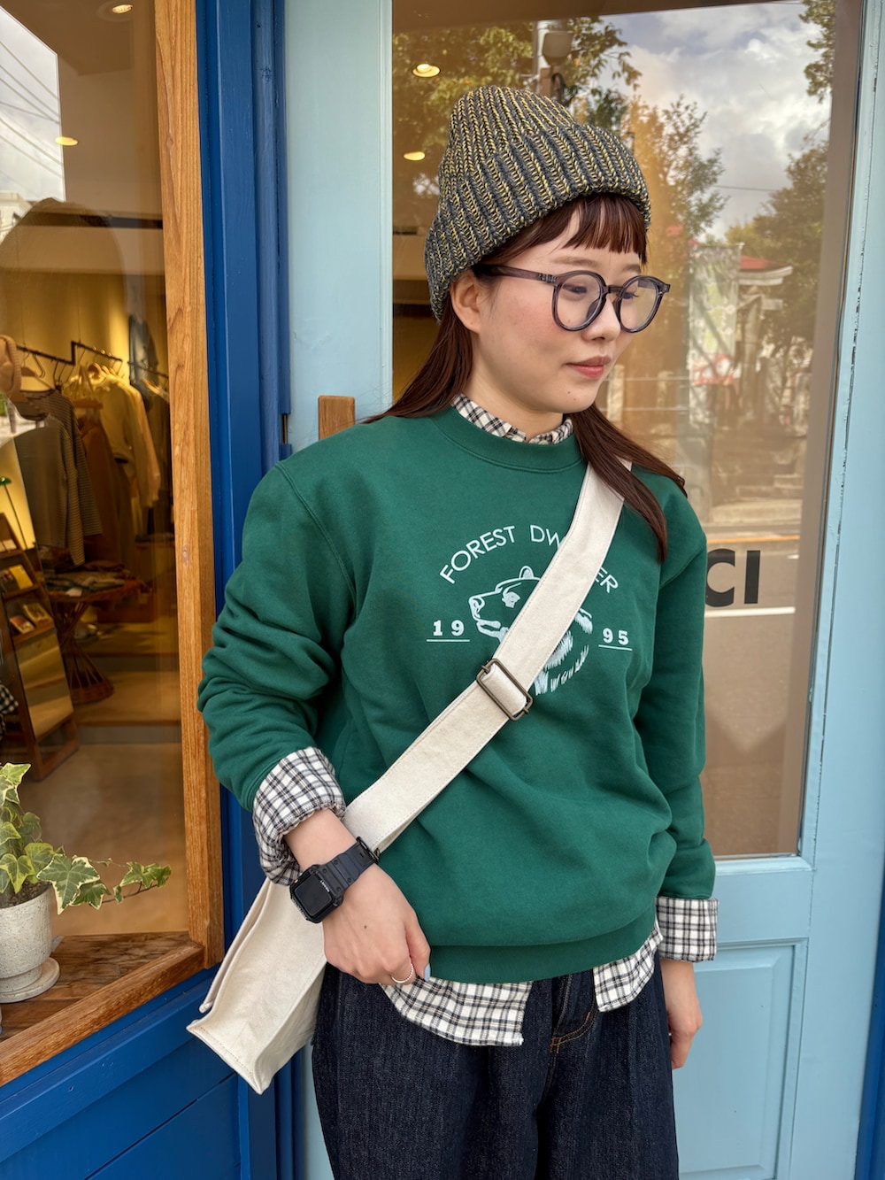 グリーン系のスウェット、ブルー系のシャツ/ブラウス、ブルー系のデニムパンツを着用したレディースの秋コーディネートの4枚目の写真