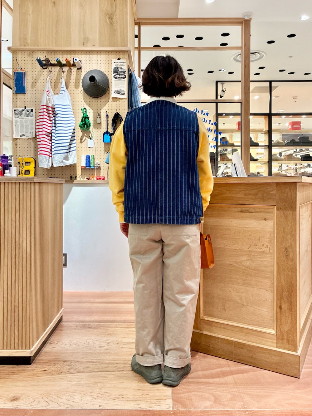 ホワイト系のTシャツ/カットソー、ブラウン系のショルダーバッグ、ベージュ系のチノパンツを着用したレディースの冬コーディネートの3枚目の写真