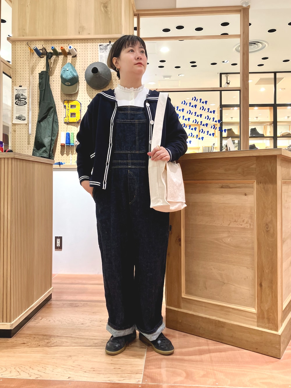 ブルー系のカーディガン/ボレロ、ホワイト系のTシャツ/カットソー、ブルー系のサロペット/オーバーオールを着用したレディースの秋コーディネートの4枚目の写真