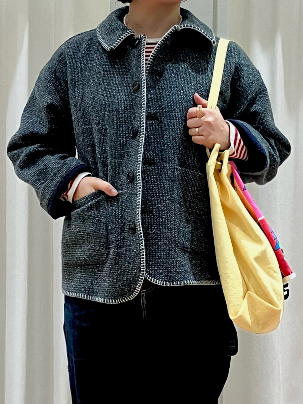 グリーン系のブルゾン、レッド系のTシャツ/カットソー、イエロー系のトートバッグを着用したレディースの冬コーディネートの5枚目の写真