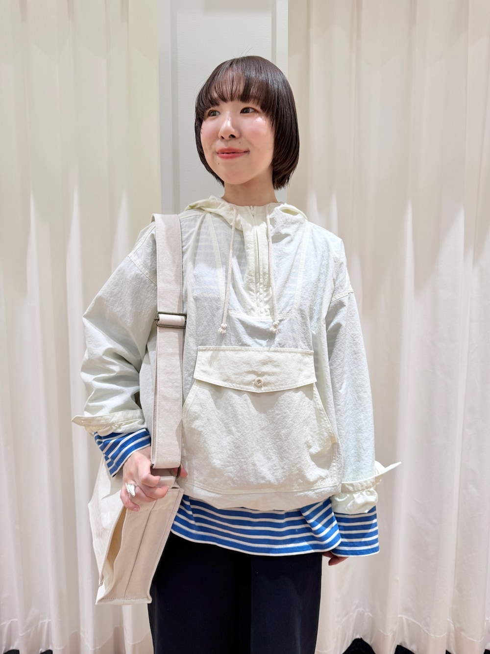 ホワイト系のその他アウター、ブルー系のチノパンツ、ホワイト系のショルダーバッグを着用したレディースの春コーディネートの5枚目の写真