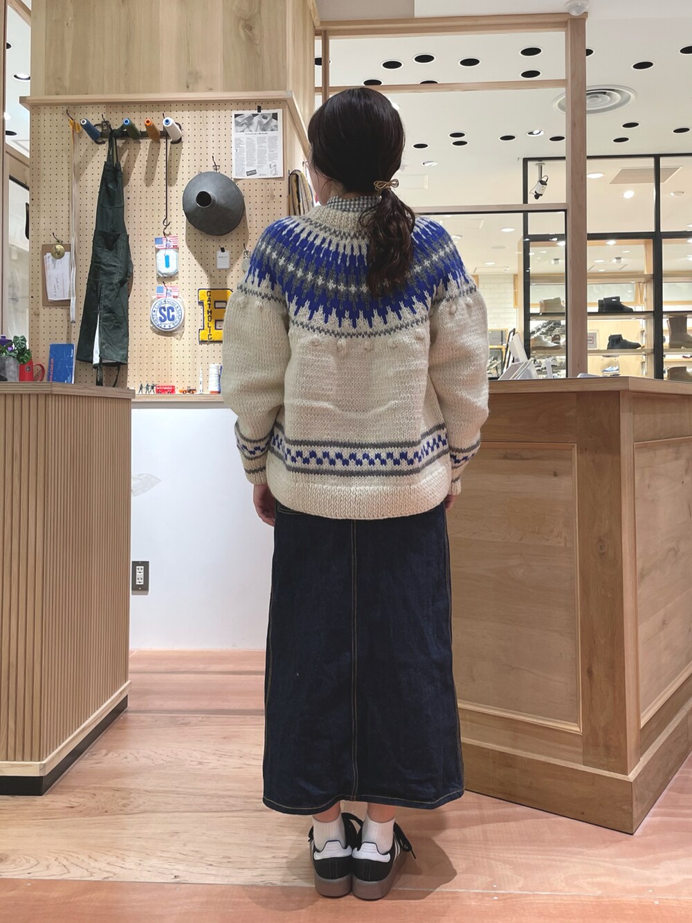 ホワイト系のカーディガン/ボレロ、グレー系のシャツ/ブラウス、ブルー系のデニムスカートを着用したレディースの秋コーディネートの3枚目の写真