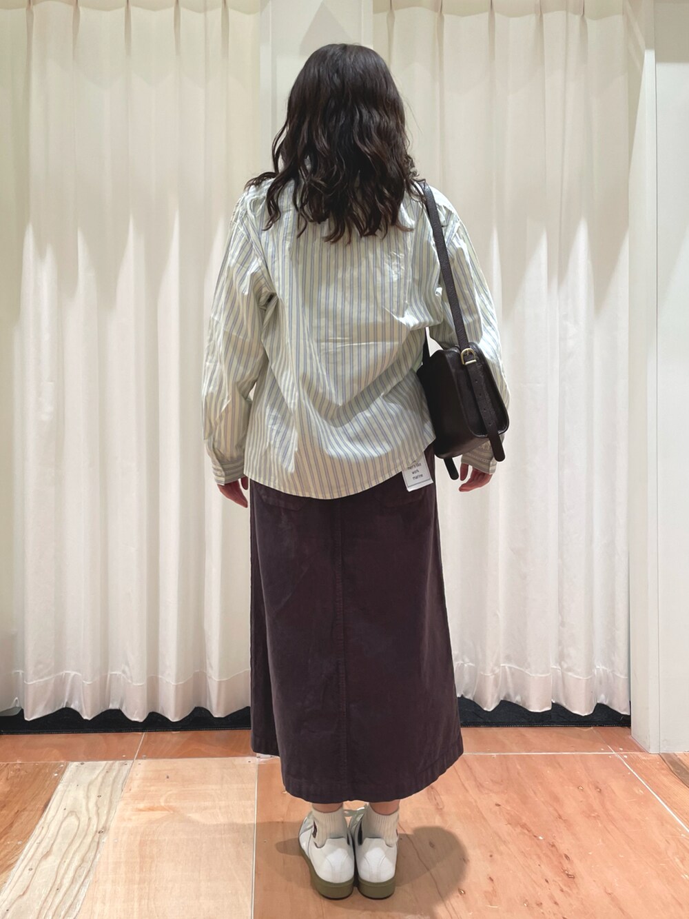 イエロー系のシャツ/ブラウス、グレー系のスカート、ホワイト系のTシャツ/カットソーを着用したレディースの冬コーディネートの3枚目の写真