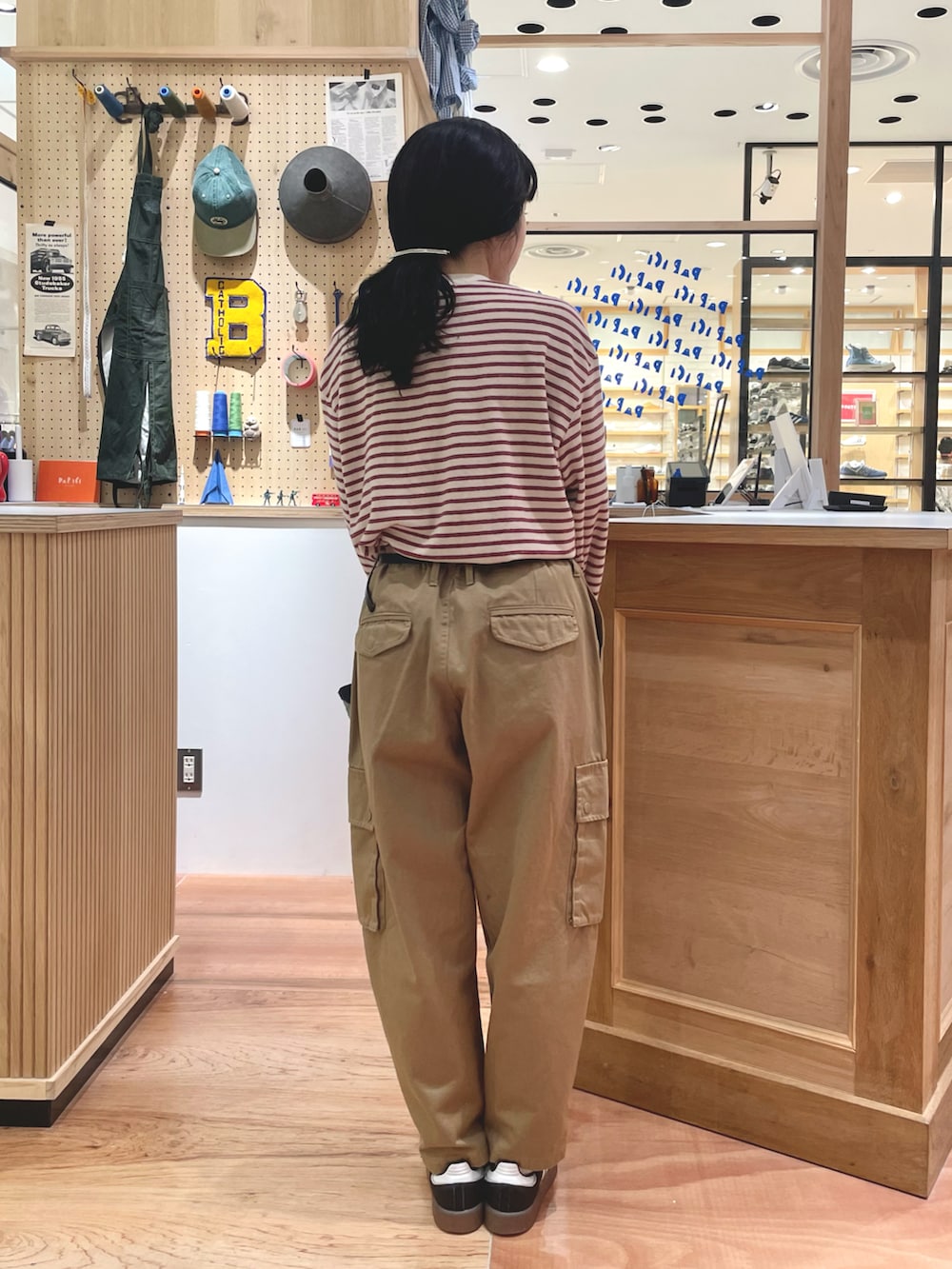 ベージュ系のカーゴパンツ、ベージュ系のTシャツ/カットソー、ブルー系のカバーオールを着用したレディースの秋コーディネートの2枚目の写真