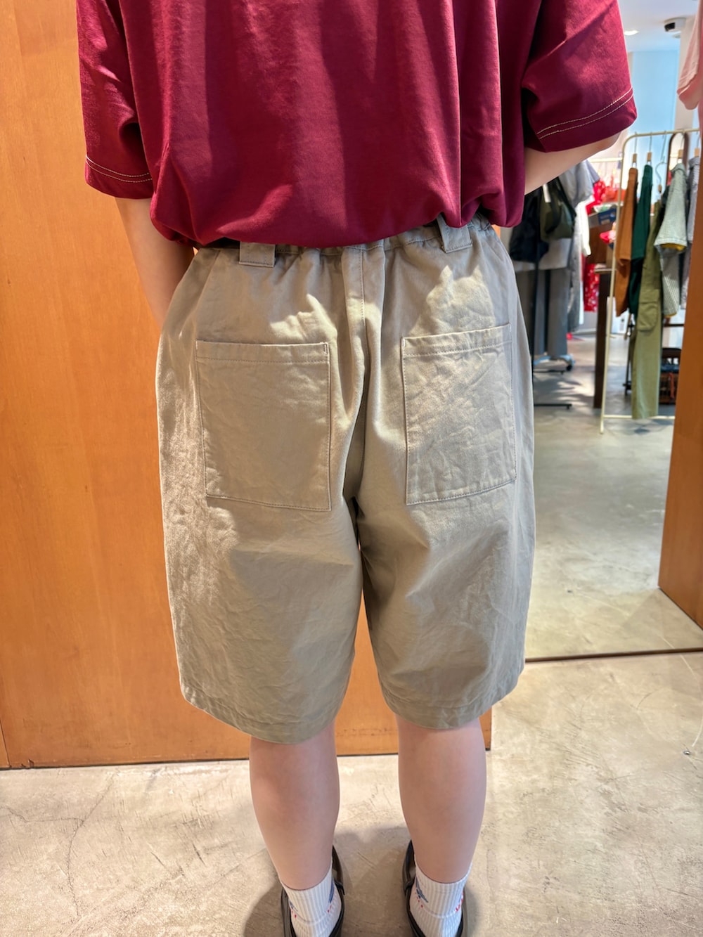 レッド系のTシャツ/カットソー、ベージュ系のチノパンツ、ブラック系のベルトを着用したレディースの夏コーディネートの7枚目の写真