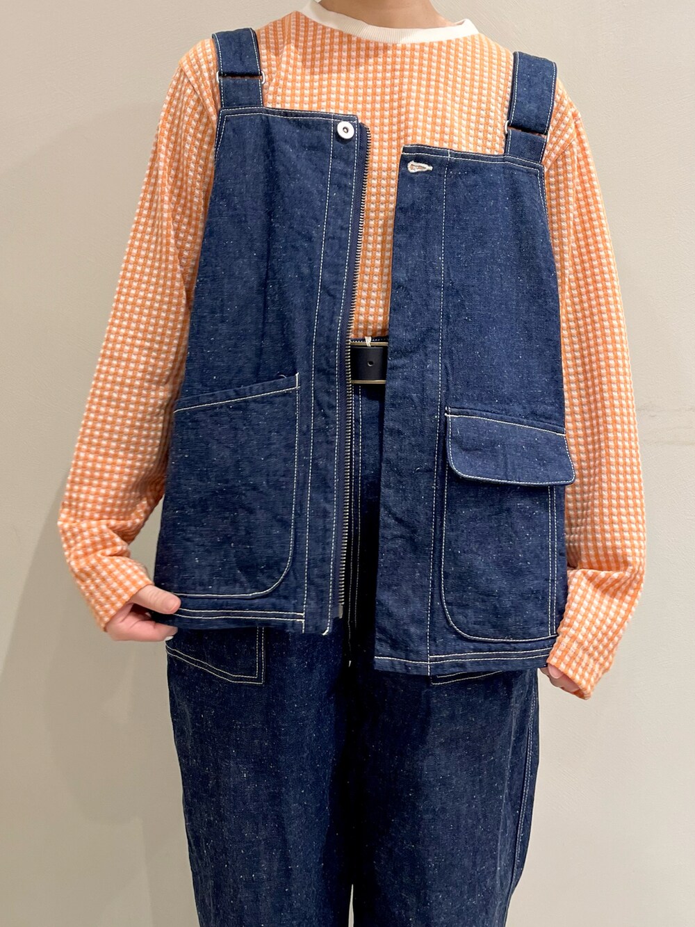 オレンジ系のTシャツ/カットソー、ブルー系のベスト、ブルー系のその他パンツを着用したレディースの冬コーディネートの4枚目の写真