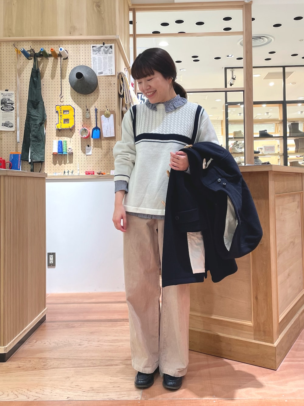 ブラック系のショルダーバッグ、ブルー系のダッフルコート、ベージュ系のその他パンツを着用したレディースの冬コーディネートの3枚目の写真