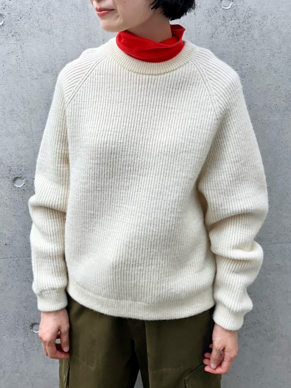 ホワイト系のニット/セーター、レッド系のTシャツ/カットソー、グリーン系のカーゴパンツを着用したレディースの秋コーディネートの4枚目の写真