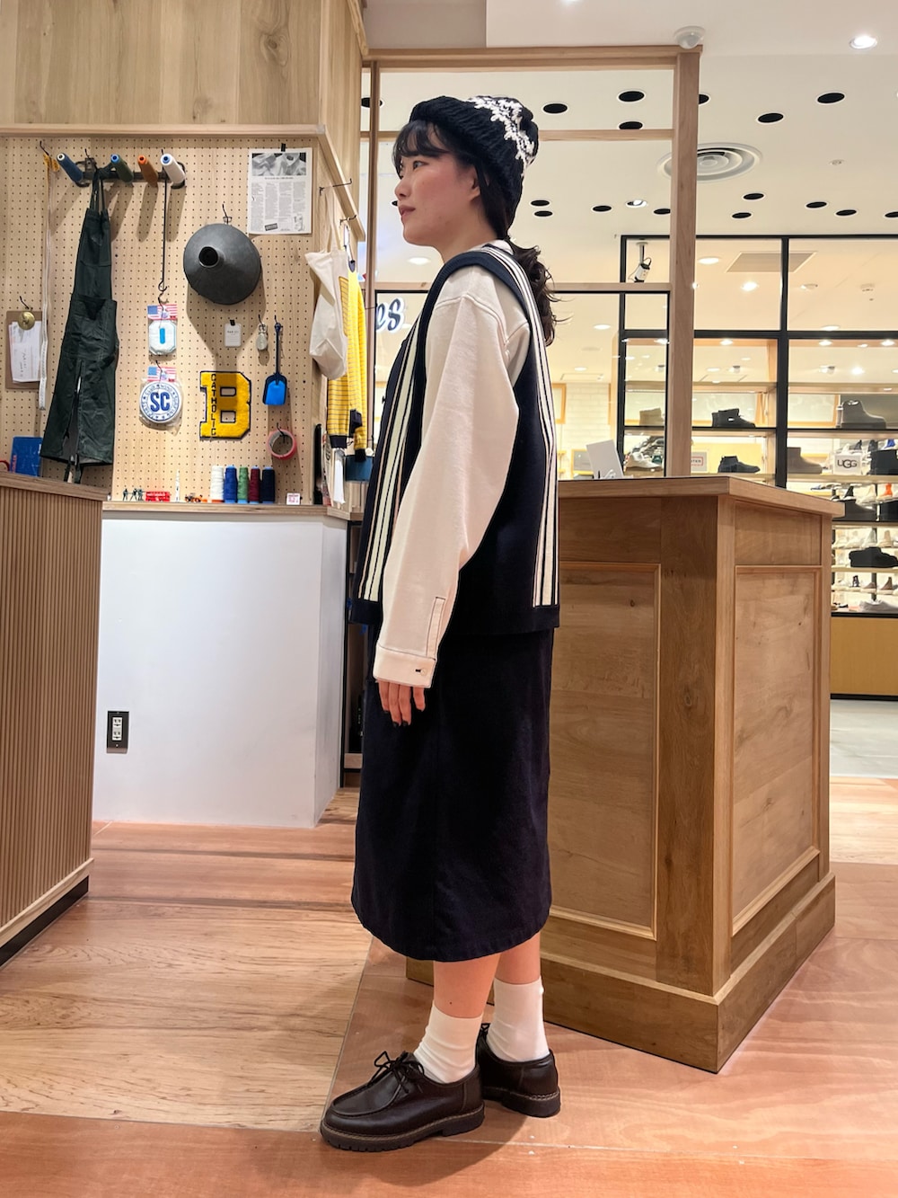 ホワイト系のシャツ/ブラウス、ブルー系のベスト、ブルー系のスカートを着用したレディースの秋コーディネートの2枚目の写真