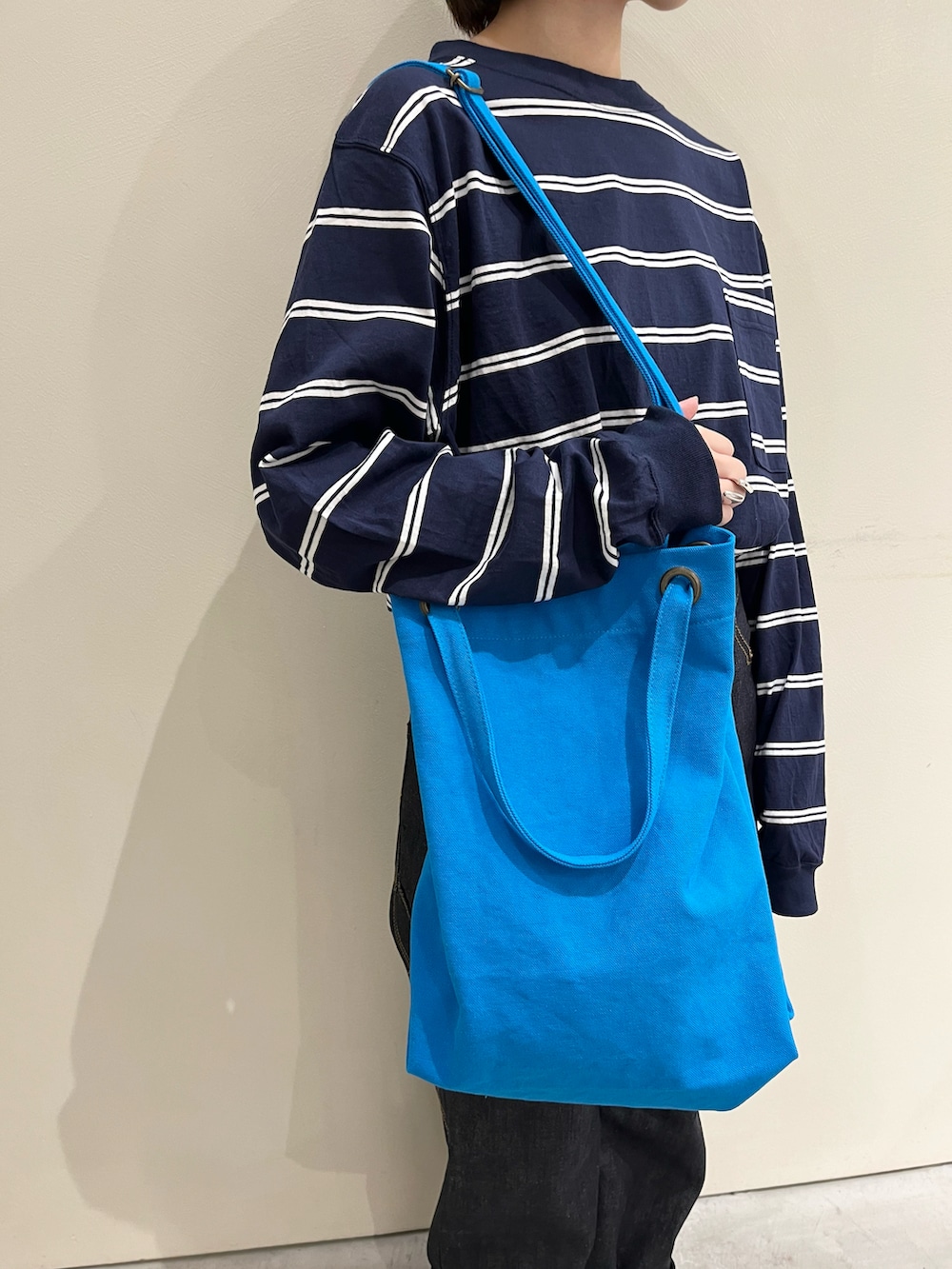 ブルー系のTシャツ/カットソー、ブルー系のデニムパンツ、ブルー系のトートバッグを着用したレディースの秋コーディネートの5枚目の写真