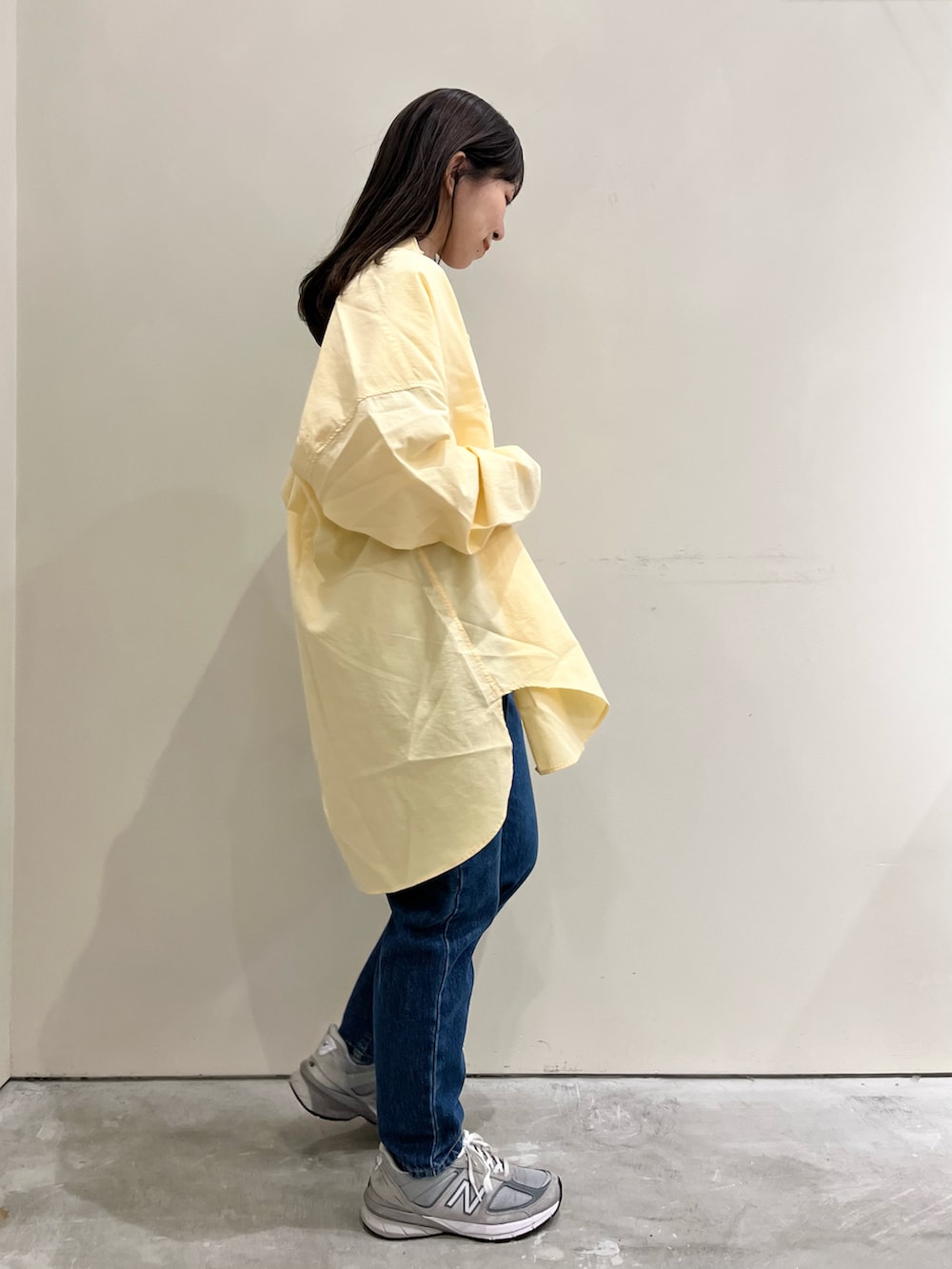 ブルー系のTシャツ/カットソー、イエロー系のシャツ/ブラウス、ブルー系のデニムパンツを着用したレディースの春コーディネートの2枚目の写真