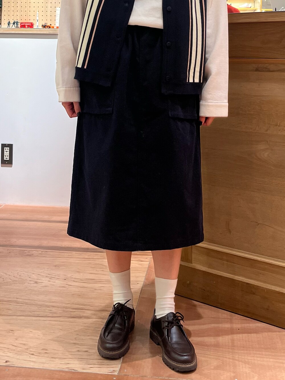 ホワイト系のシャツ/ブラウス、ブルー系のベスト、ブルー系のスカートを着用したレディースの秋コーディネートの5枚目の写真