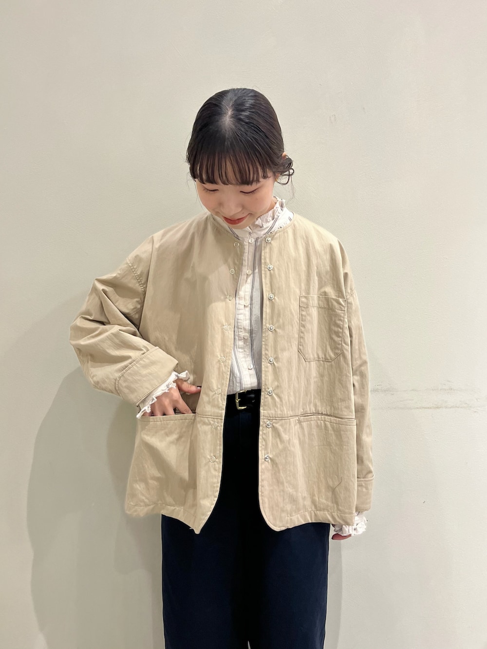 ベージュ系のシャツ/ブラウス、ベージュ系のノーカラージャケット、ブルー系のチノパンツを着用したレディースの秋コーディネートの5枚目の写真