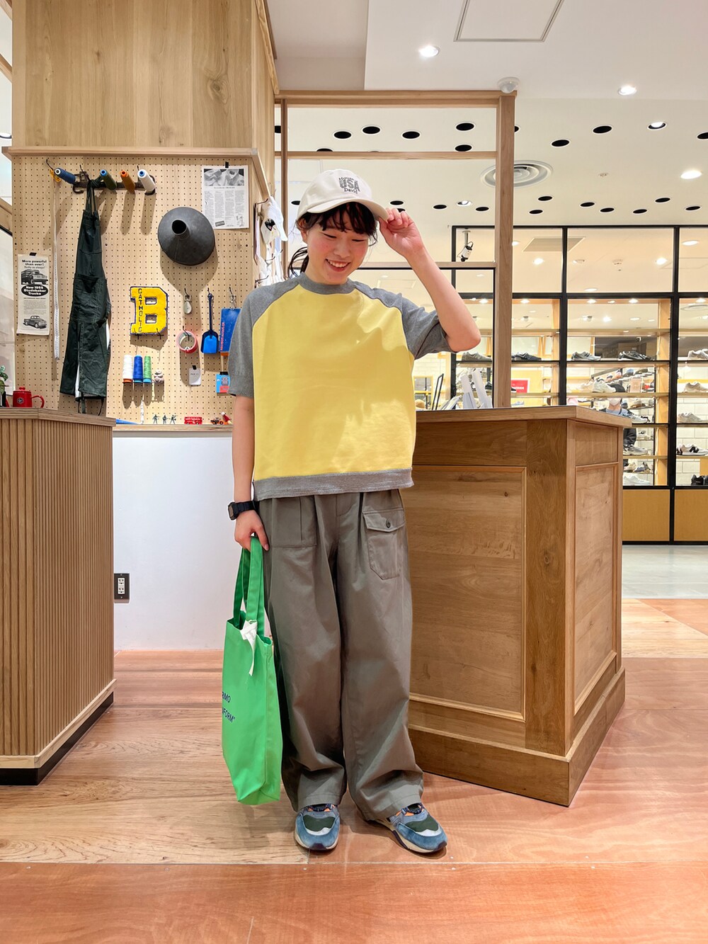 イエロー系のTシャツ/カットソー、ブルー系のベスト、グリーン系のその他パンツを着用したレディースの春コーディネートの4枚目の写真