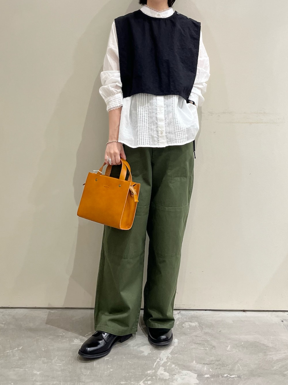 ブラック系のベスト、ホワイト系のシャツ/ブラウス、グリーン系のその他パンツを着用したレディースの夏コーディネートの3枚目の写真