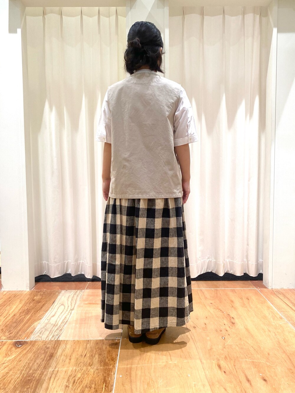 ホワイト系のシャツ/ブラウス、ベージュ系のベスト、ブラック系のスカートを着用したレディースの夏コーディネートの3枚目の写真
