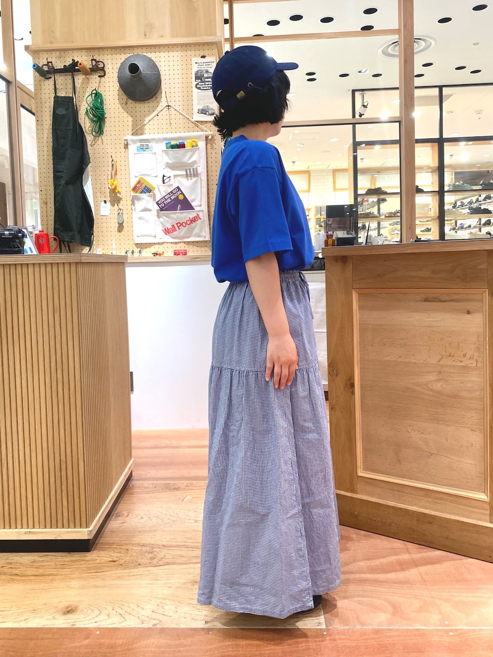 ブルー系のスカート、ブルー系のTシャツ/カットソー、ブルー系のキャップを着用したレディースの夏コーディネートの2枚目の写真