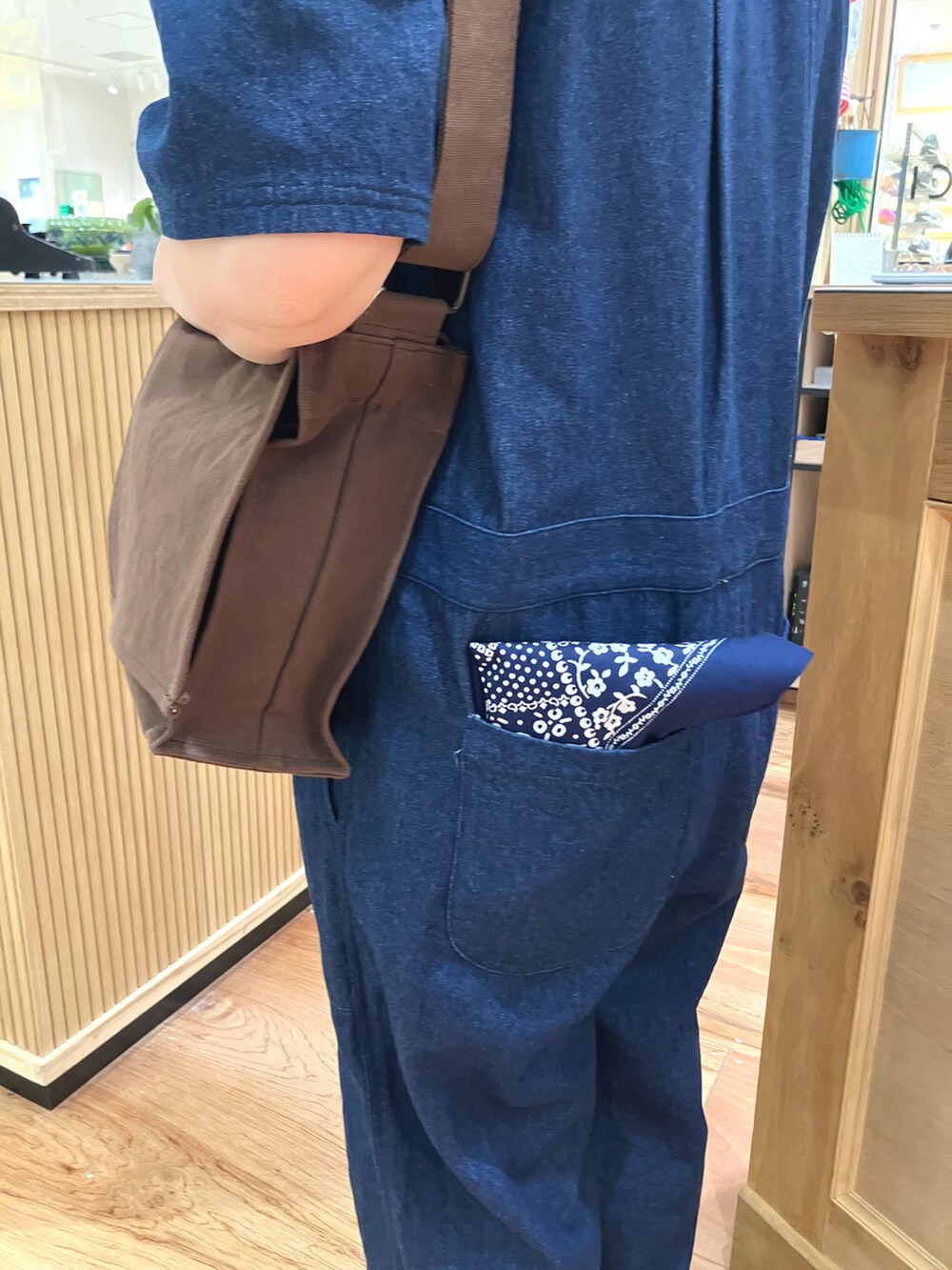 ブルー系のつなぎ/オールインワン、ブラウン系のショルダーバッグ、ホワイト系のタンクトップを着用したレディースの春コーディネートの5枚目の写真