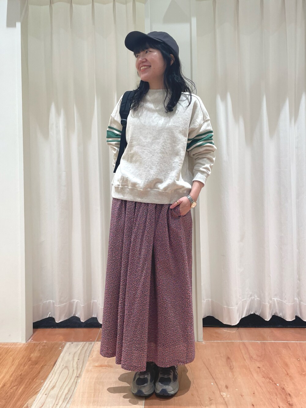 レッド系のスカート、ホワイト系のスウェットを着用したレディースの冬コーディネートの2枚目の写真