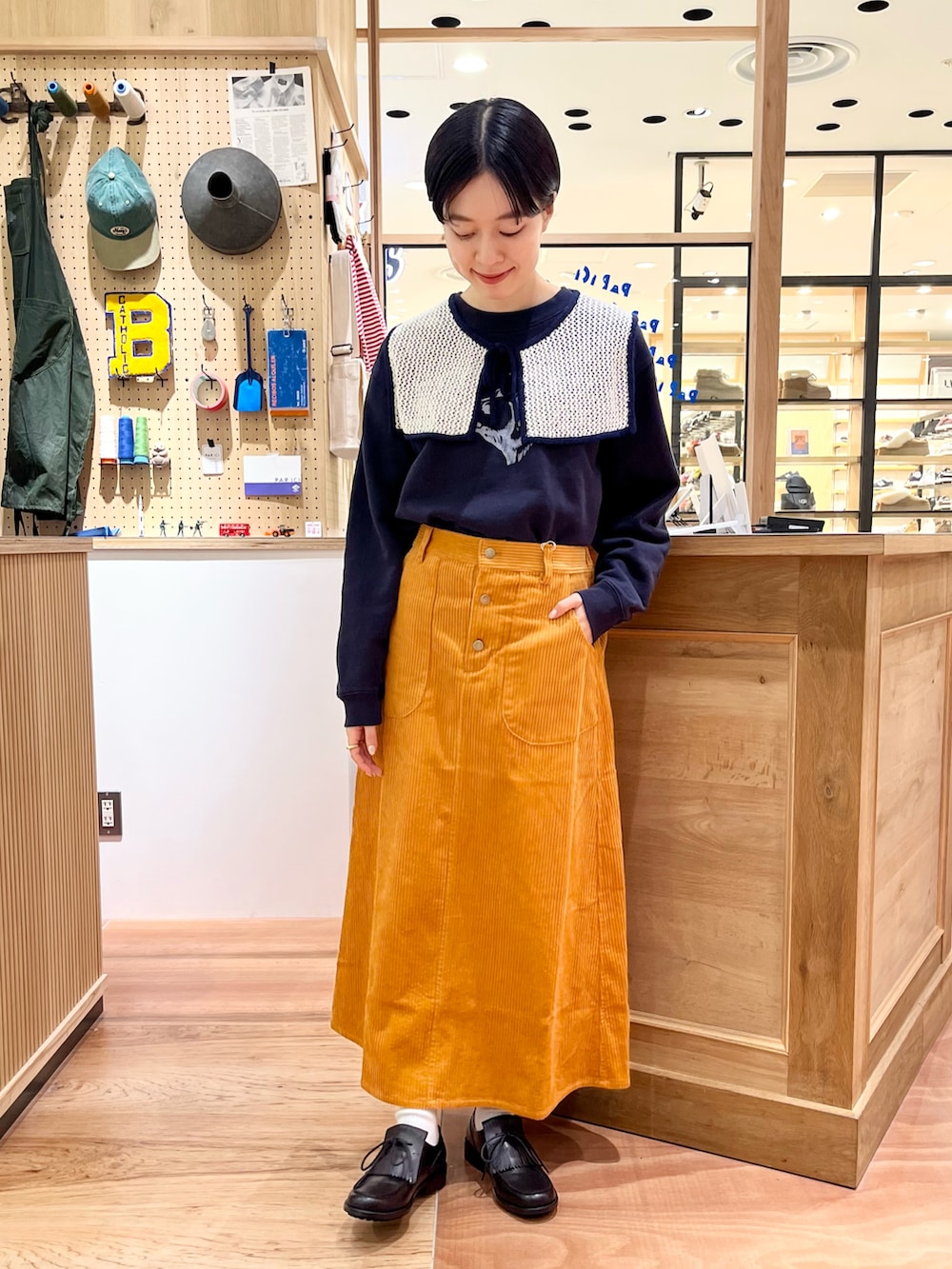 ブルー系のスウェット、イエロー系のスカート、ホワイト系の付け襟を着用したレディースの秋コーディネートの4枚目の写真