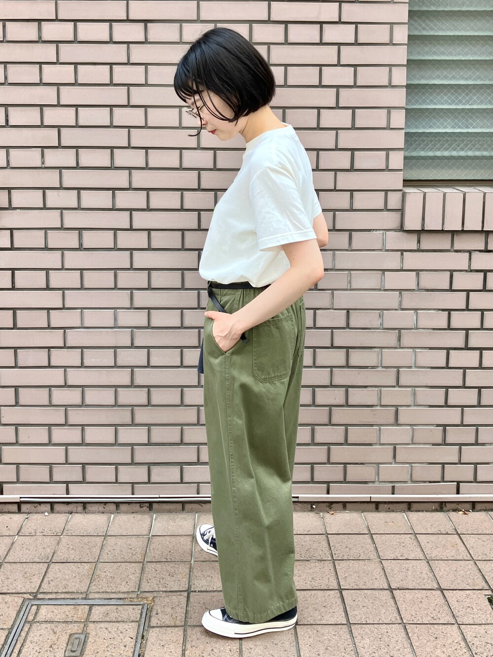 ホワイト系のTシャツ/カットソー、グリーン系のチノパンツ、ブラック系のベルトを着用したレディースの夏コーディネートの2枚目の写真